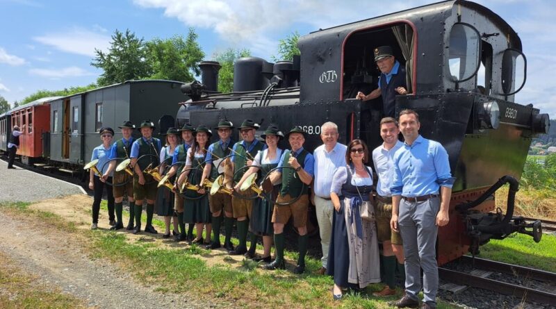 Vize-Bgm. Michael Baumgartner, Stadtrat Philipp Strutz, Vize-Bgmin. Doris Hofstätter, Bürgermeister Walter Zemrosser (von rechts) mit Gerd Schneider in der Gurkthalbahn sowie der Jagdhornbläsergruppe Althofen-Guttaring